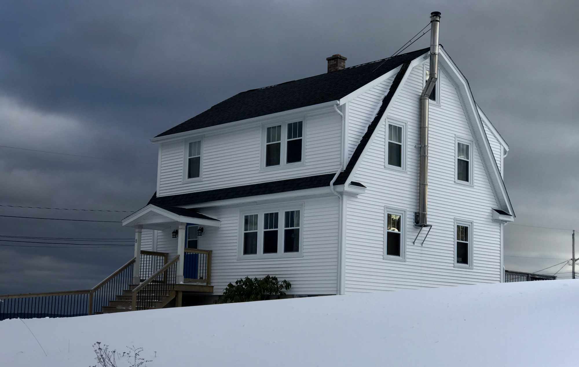 A Nova Scotia House in snow. Dramatic lighting. Supports renovation ideas Nova Scotia.