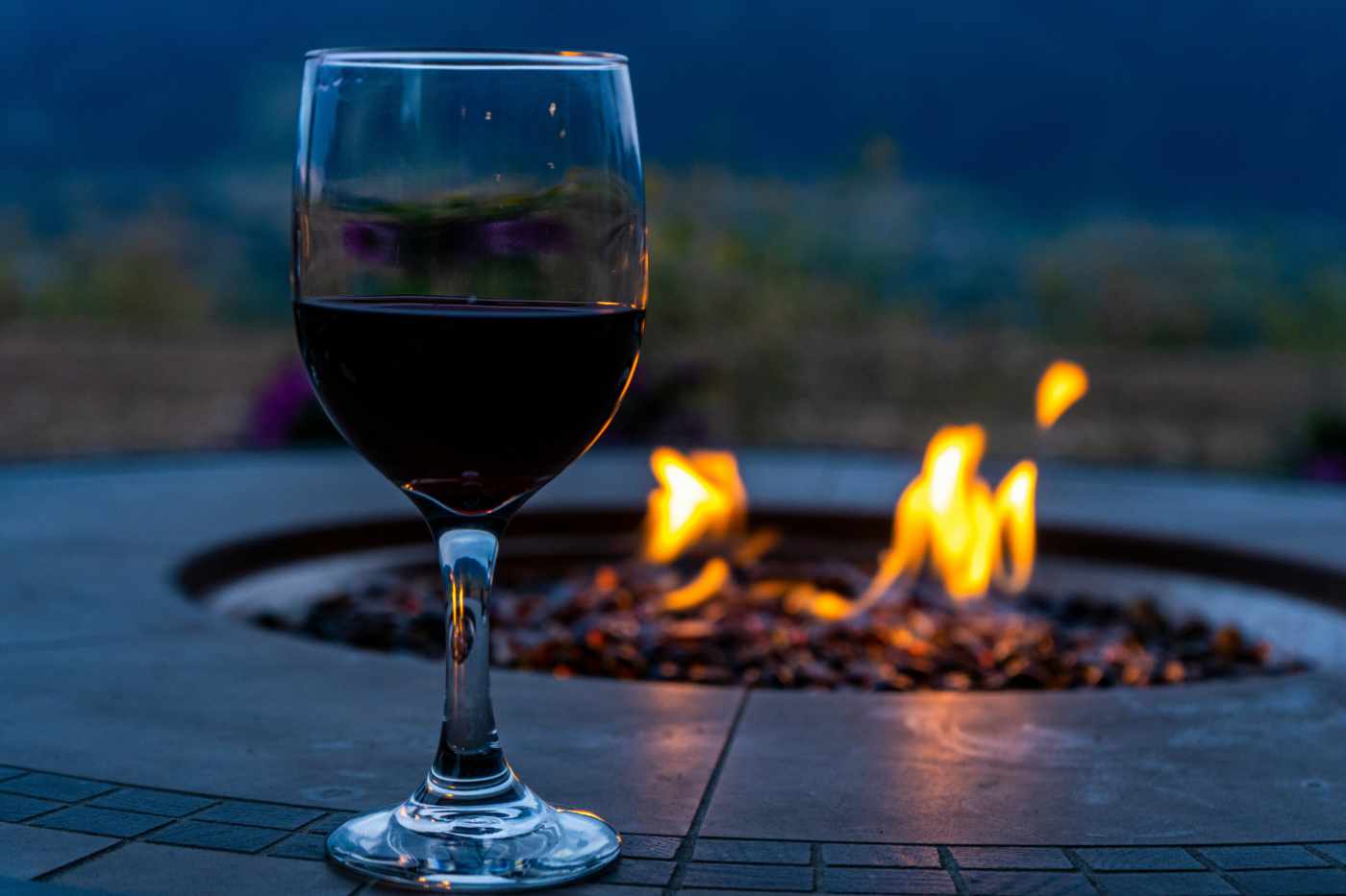 Glass of wine next to a fire pit. Outside spaces.